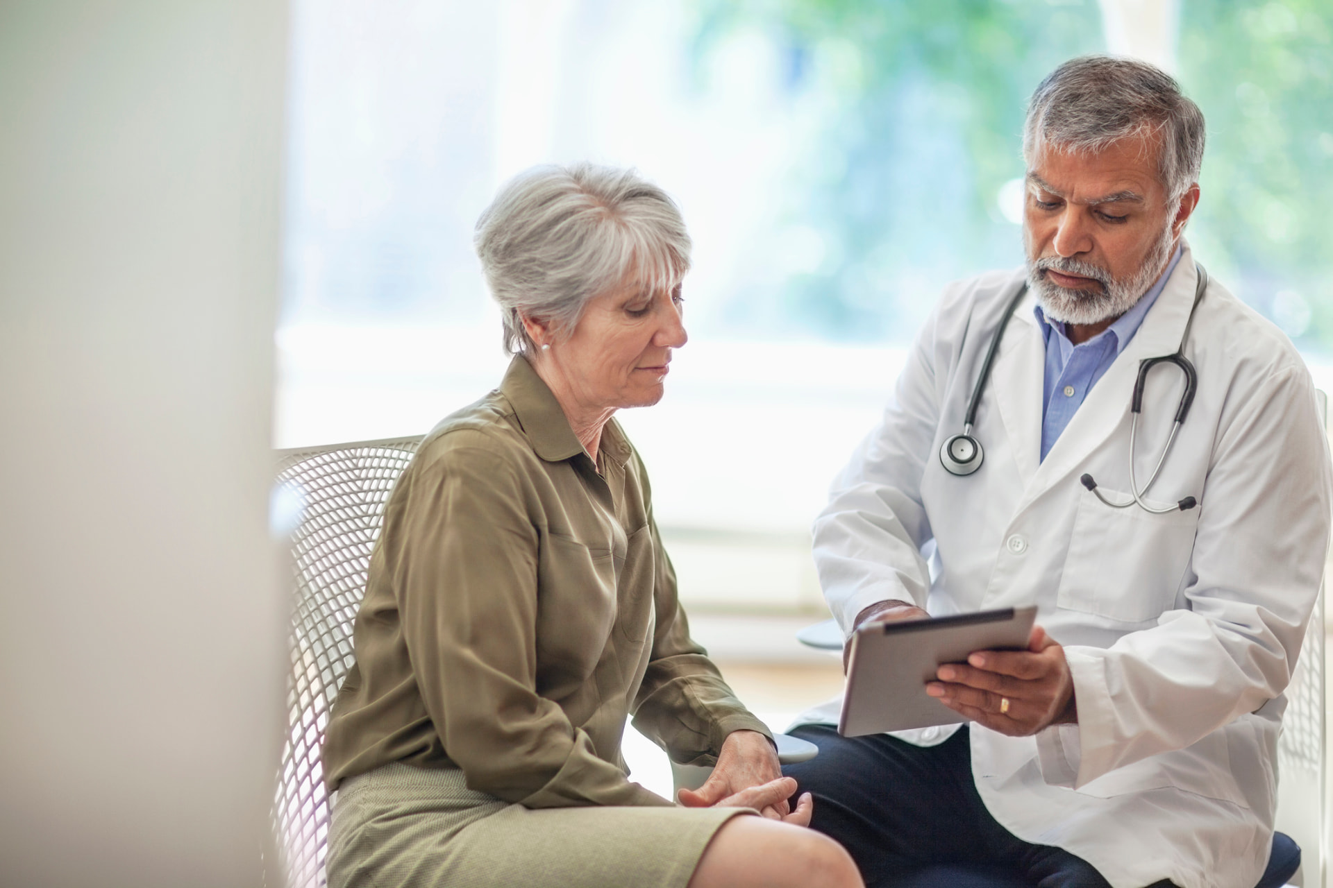 A clinician reviewing results on a tablet with a patient during an office visit